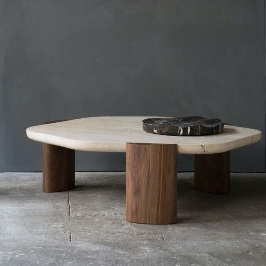 Table basse sculpturale en pierre naturelle et bois de noyer, alliance d’élégance et de robustesse.