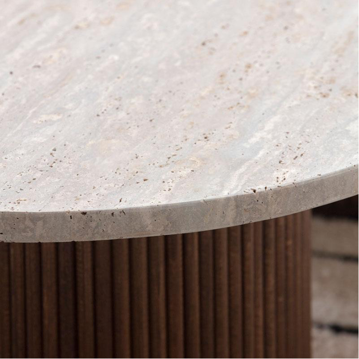 Vue détaillée d'une table en travertin ovale avec pieds cylindriques en bois sculpté, parfaite pour un salon raffiné.