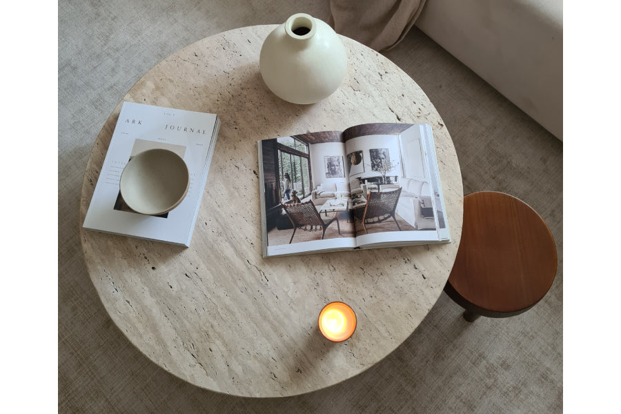 Table basse ronde en pierre naturelle avec un pied cylindrique à rainures.