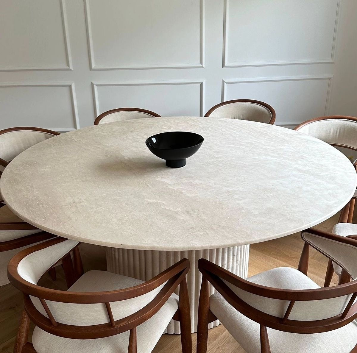 Table en travertin avec pied baguette, pièce maîtresse pour un intérieur minimaliste et raffiné.