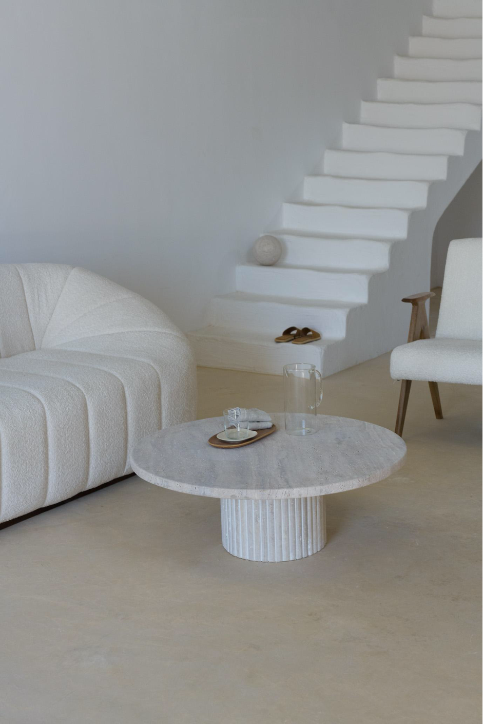 Vue de profil d'une table basse en travertin avec un pied rainuré.