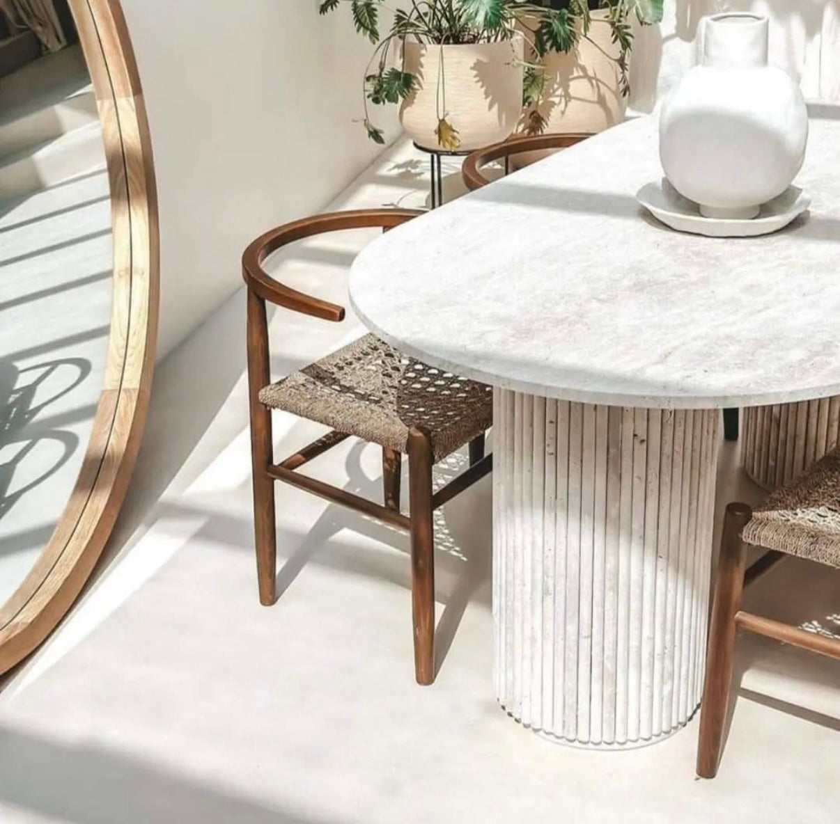 Table en travertin avec plateau fin et pieds sculptés, équilibre parfait entre robustesse et légèreté.