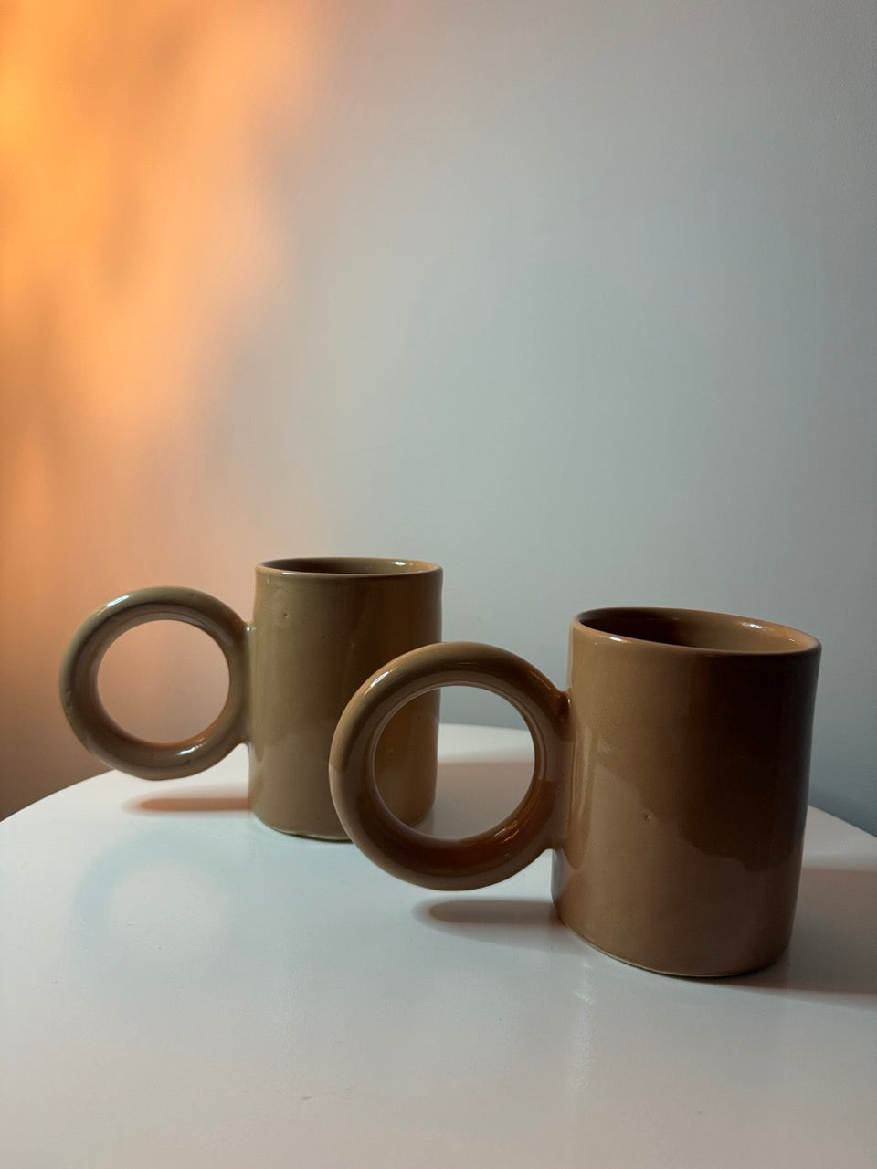 Duo de mugs faits à la main en céramique, finition lisse et anse circulaire originale.