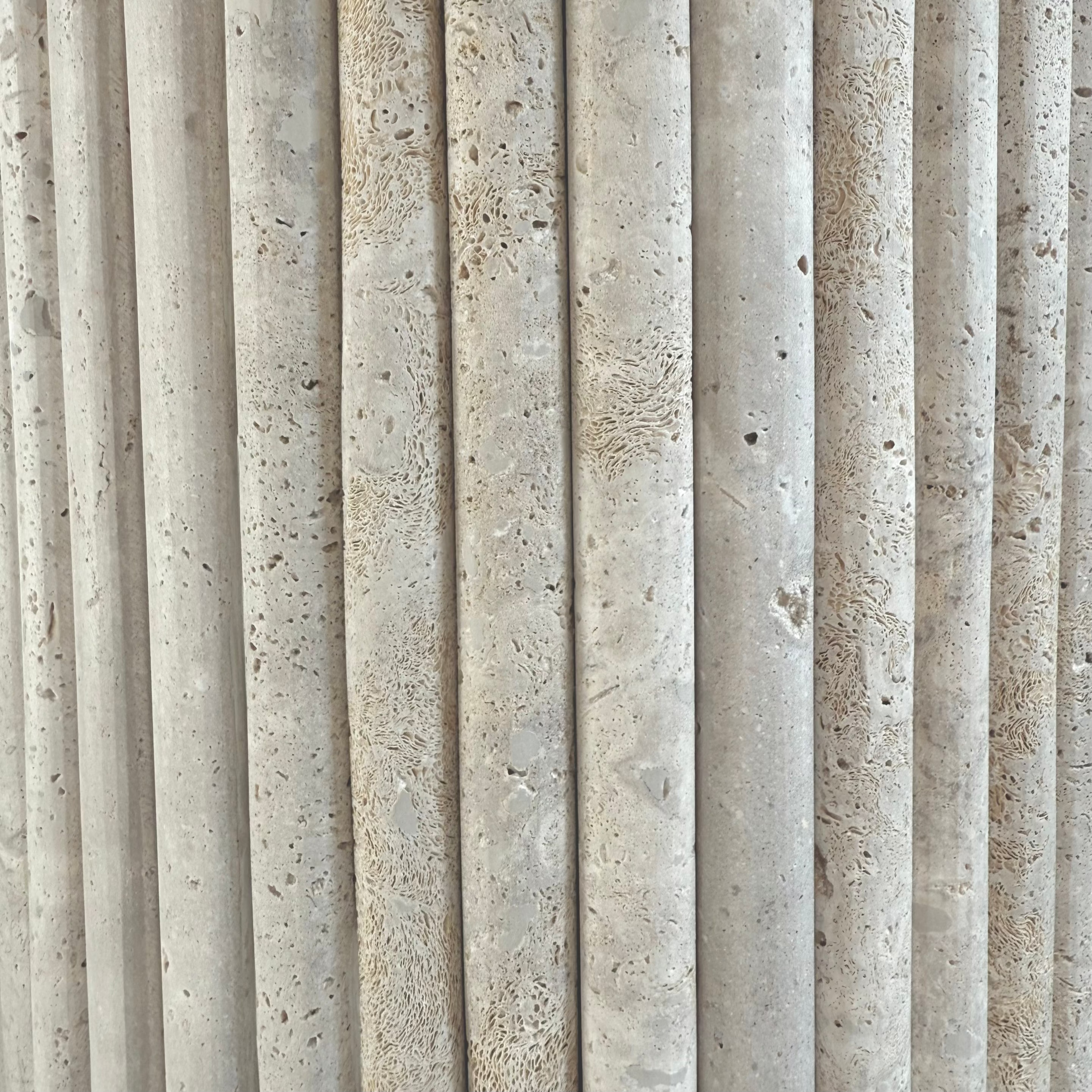 Détail du pied en travertin cannelé d’un bureau en noyer massif fabriqué sur mesure.